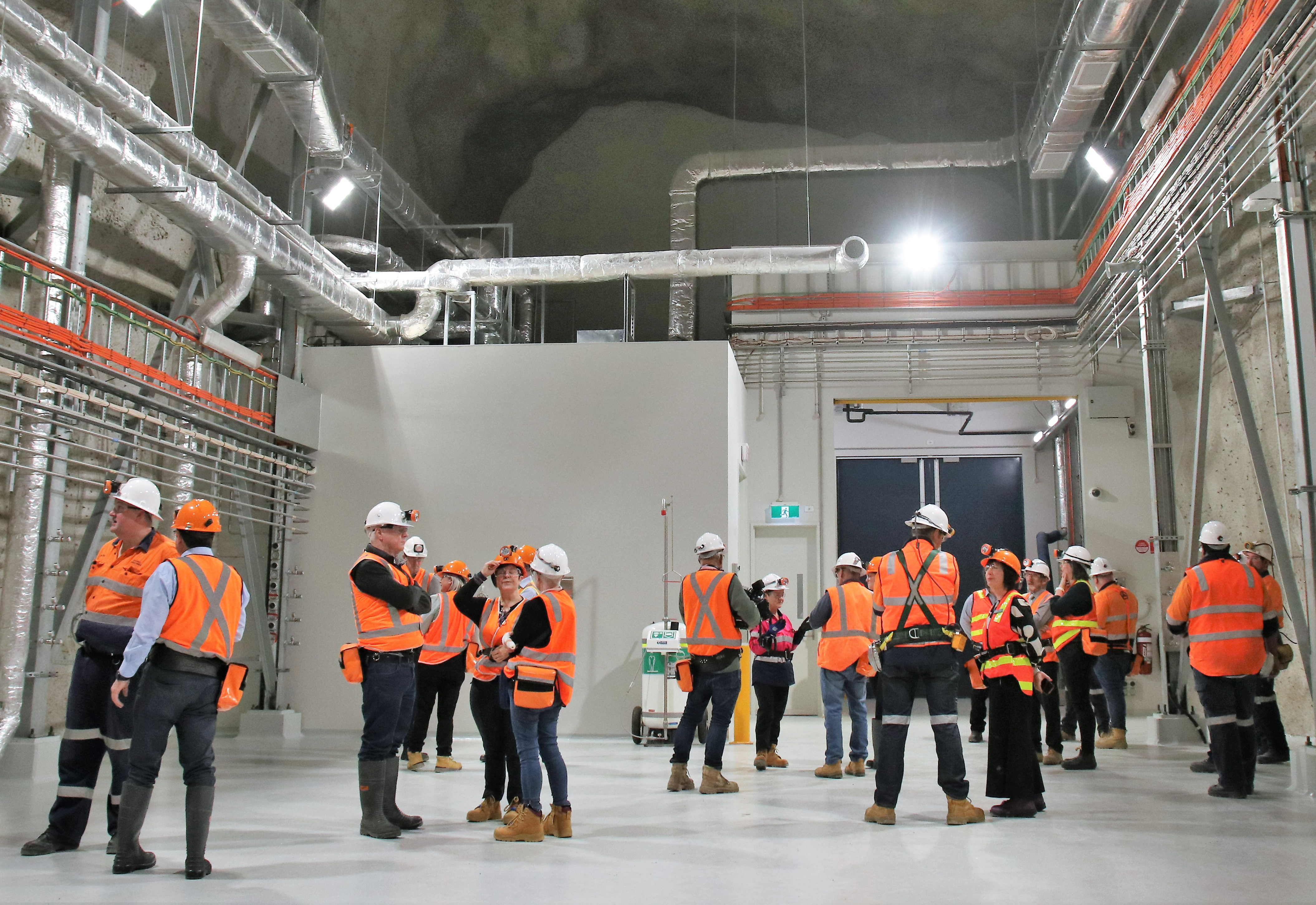 Researchers in an underground laboratory wearing helmet and hi-vis vests