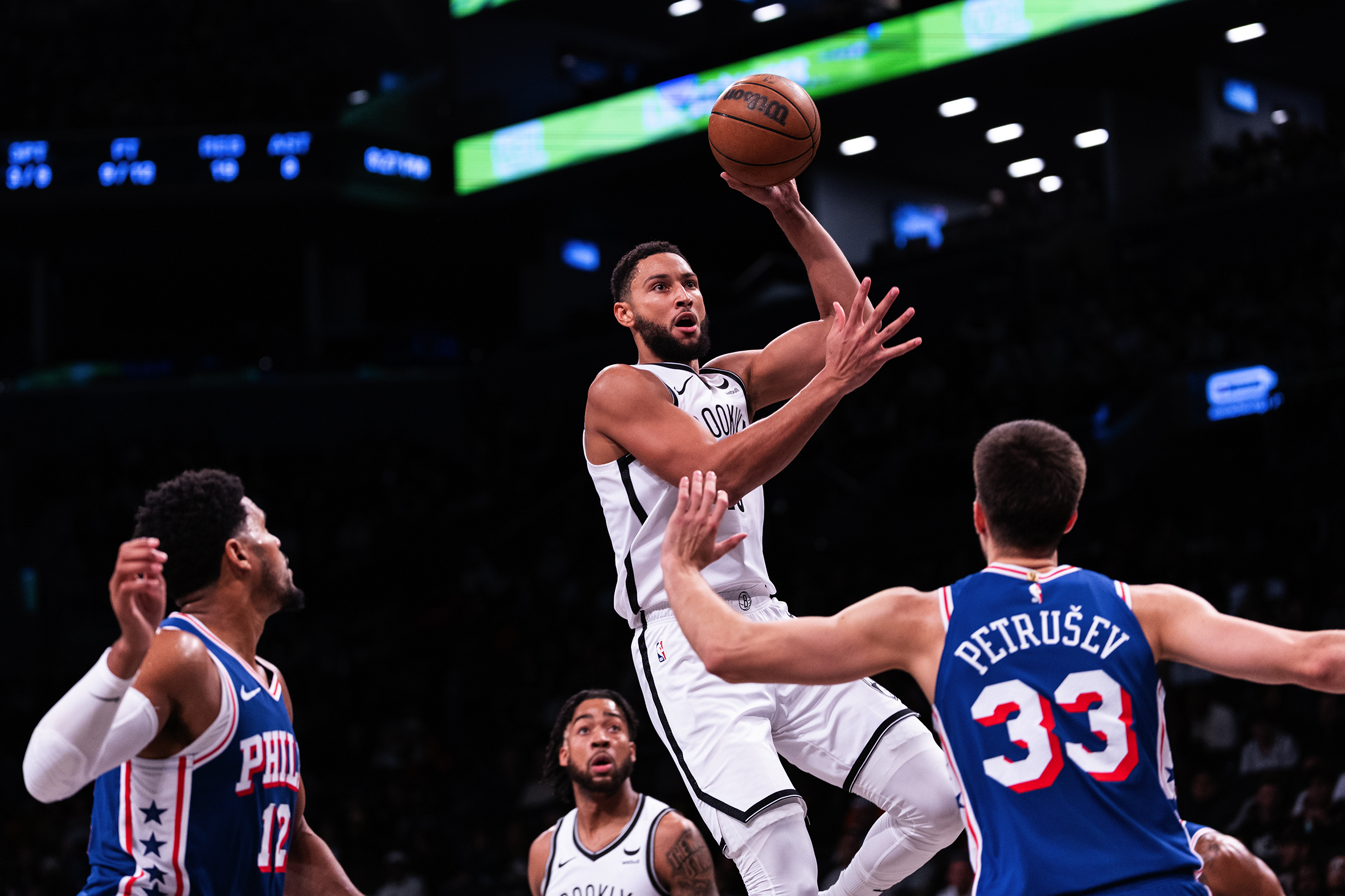 A basketball player midair as defenders surround him.