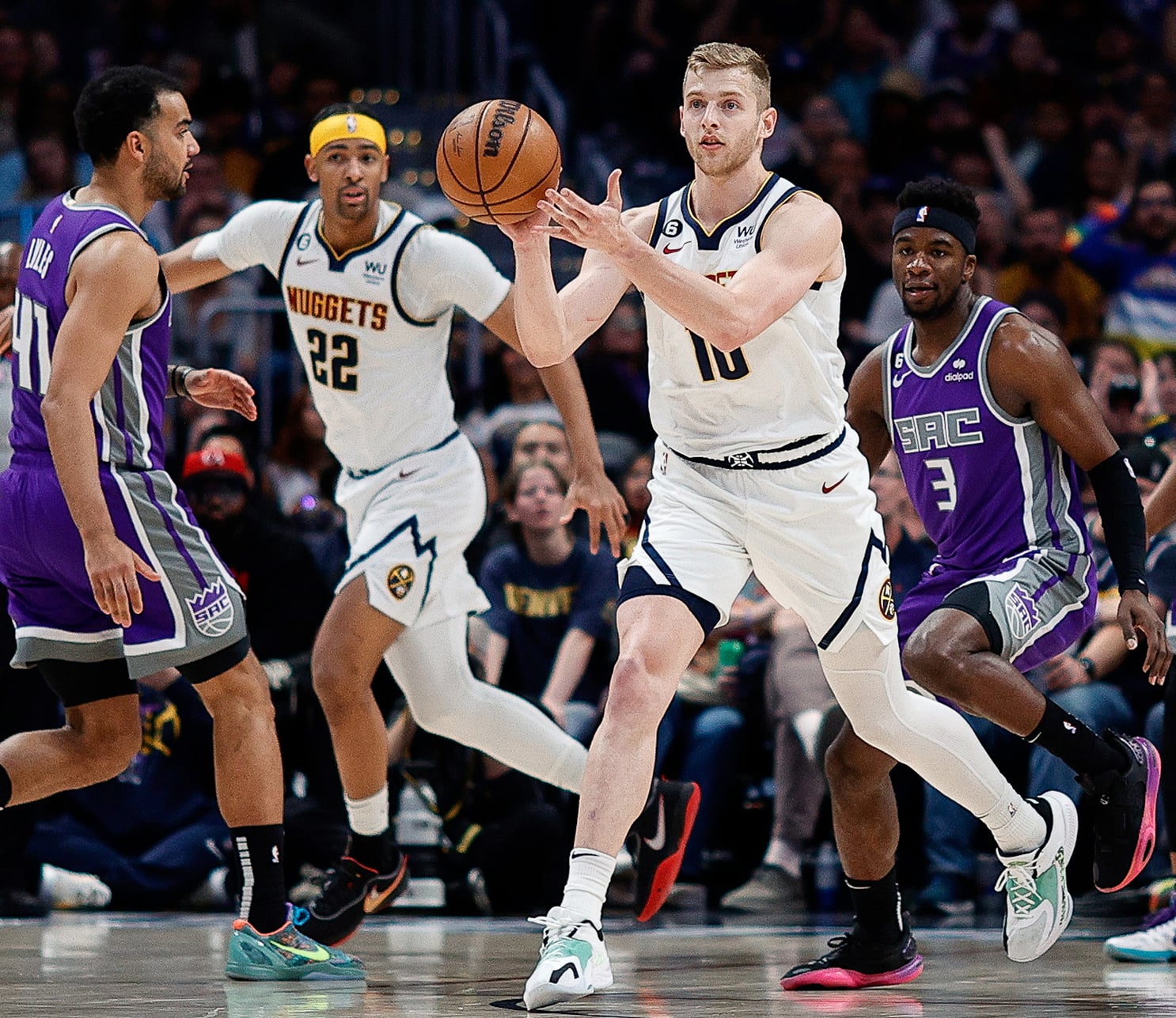 Basketball players running on court.
