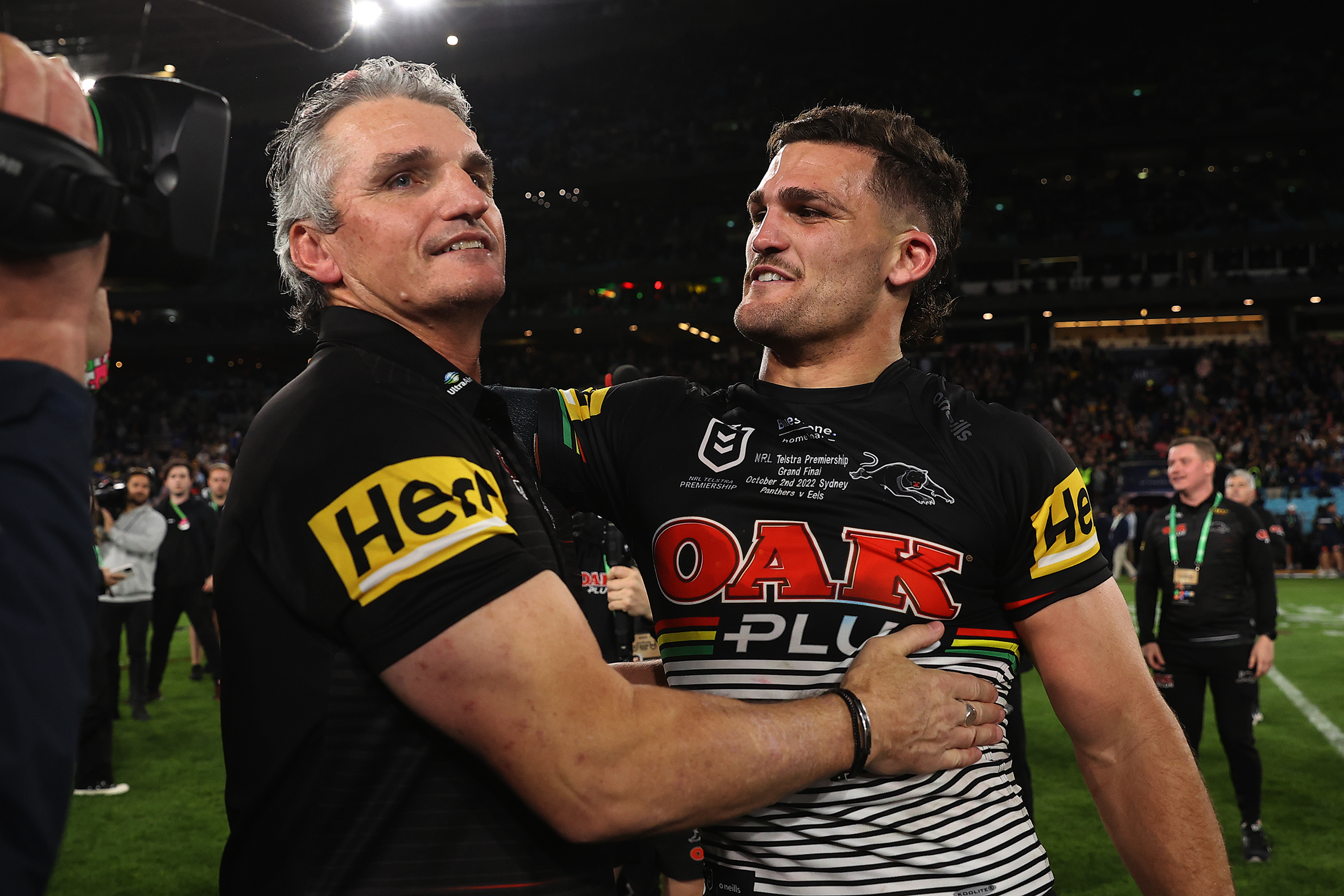 A father and son embrace on a a football pitch.