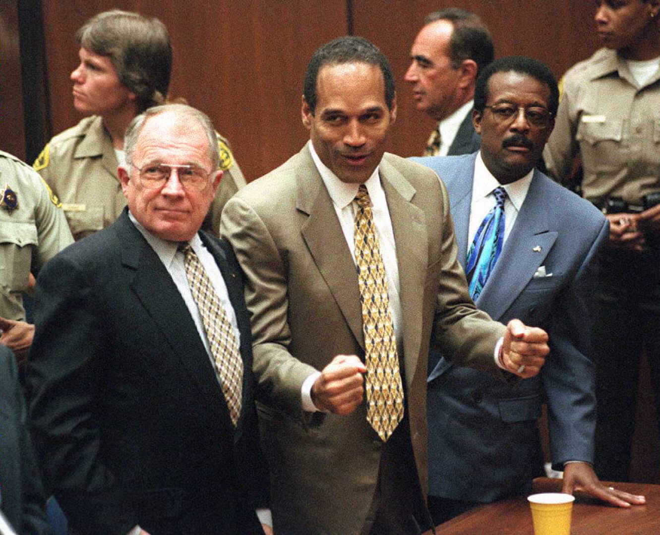 O. J. Simpson in a courtroom and flanked by his lawyers.