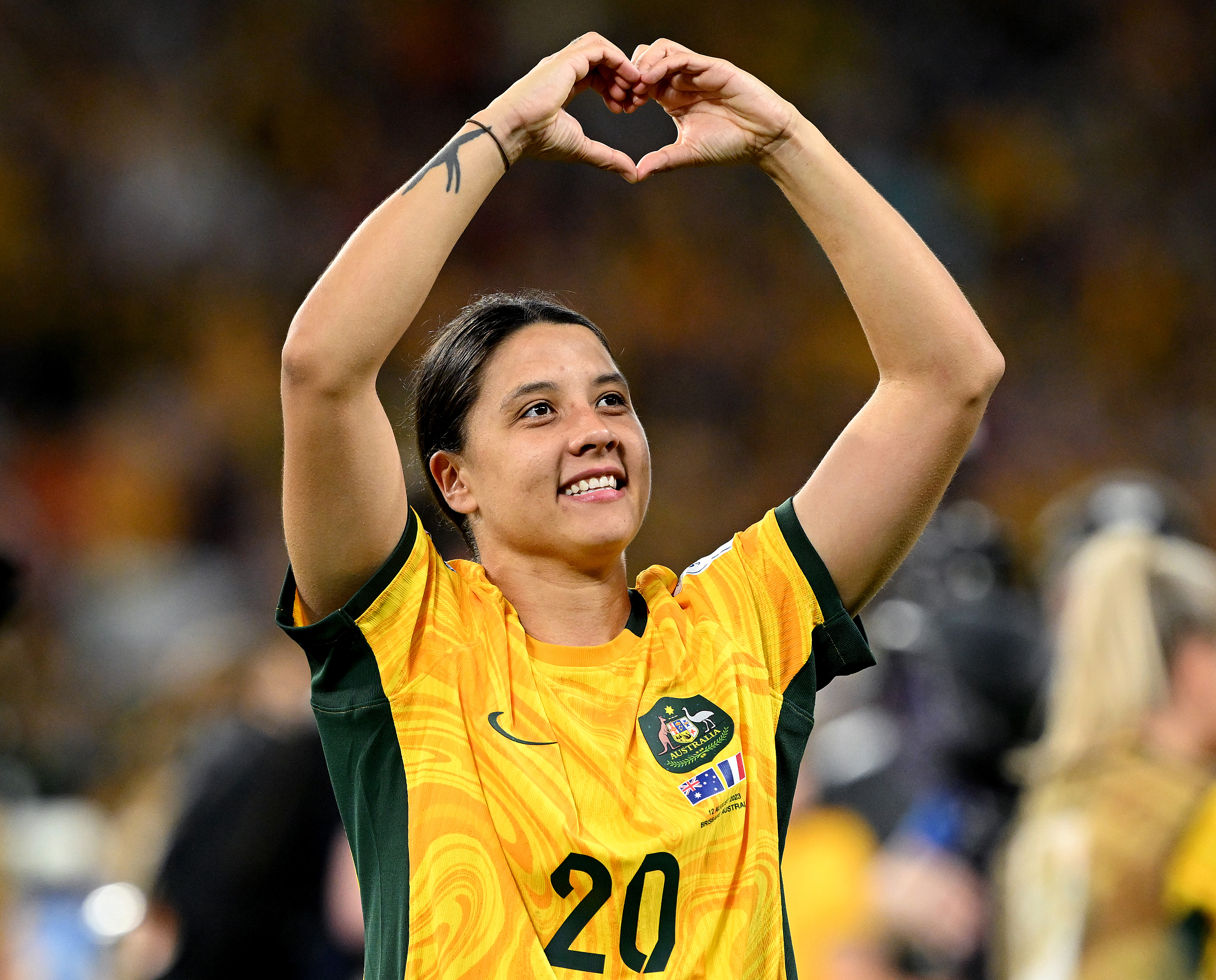 Sam Kerr makes a heart with her hands.