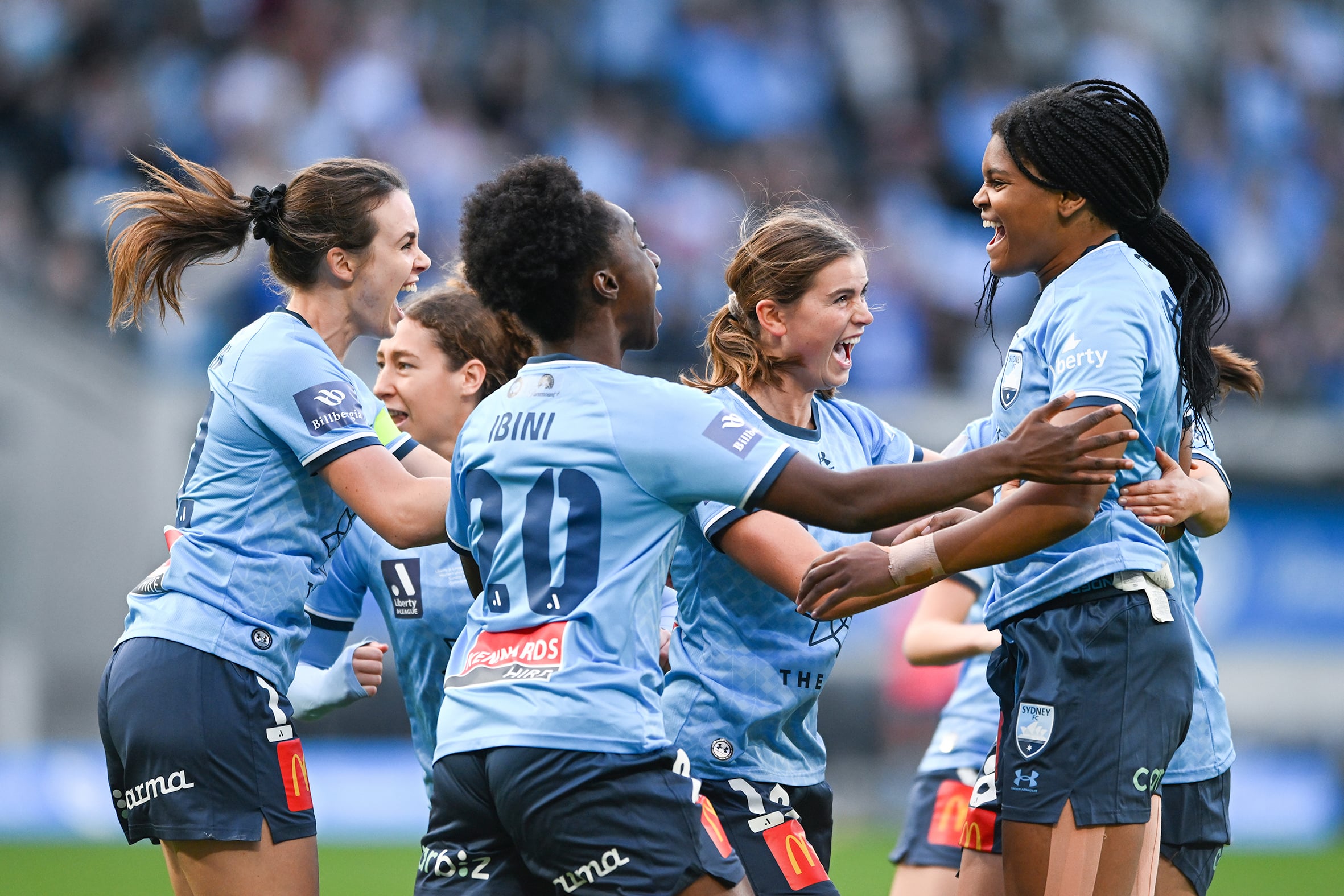 Players of Sydney FC celebrate on-field.