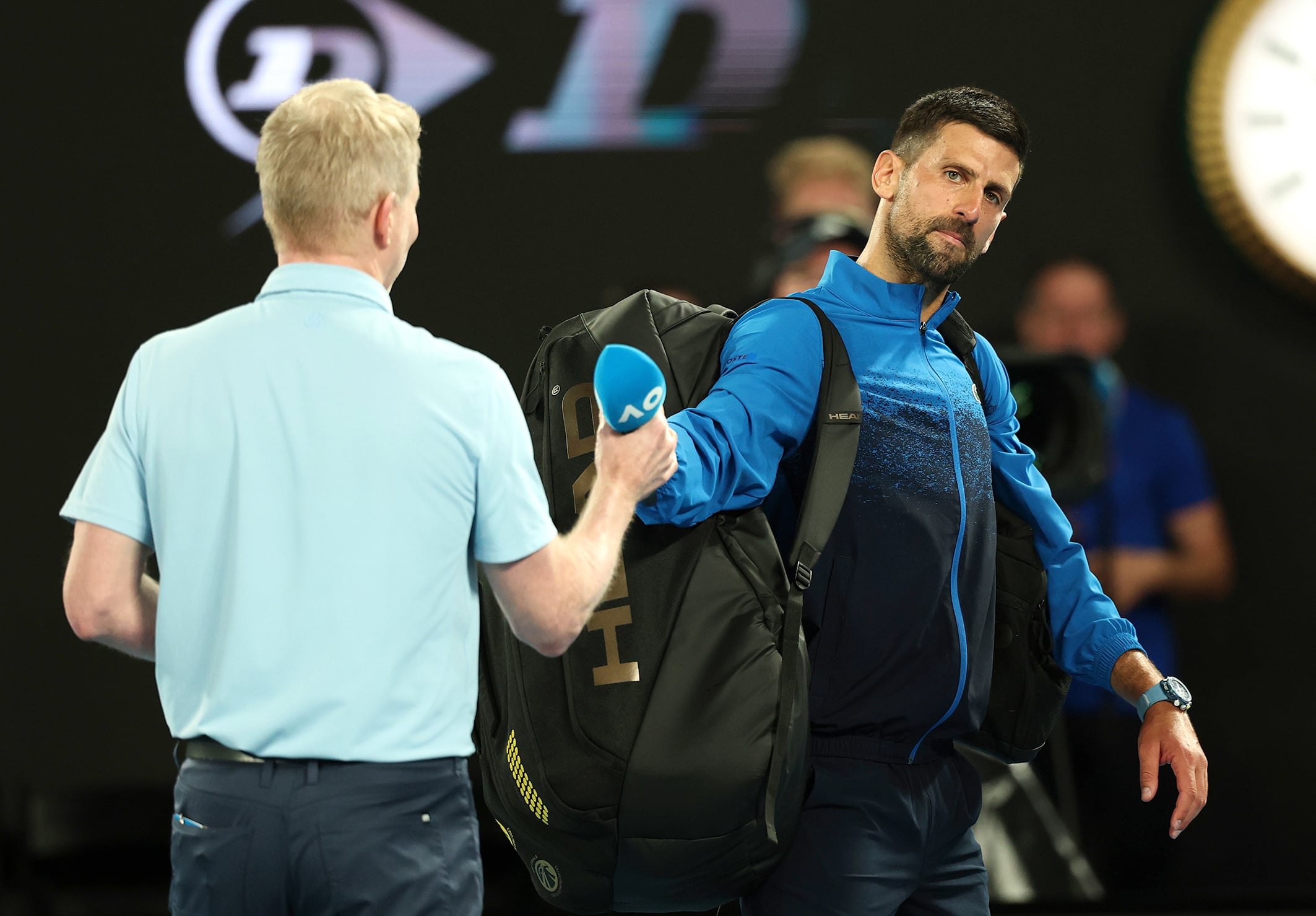 Novak Djokovic on court with Jim Courier.