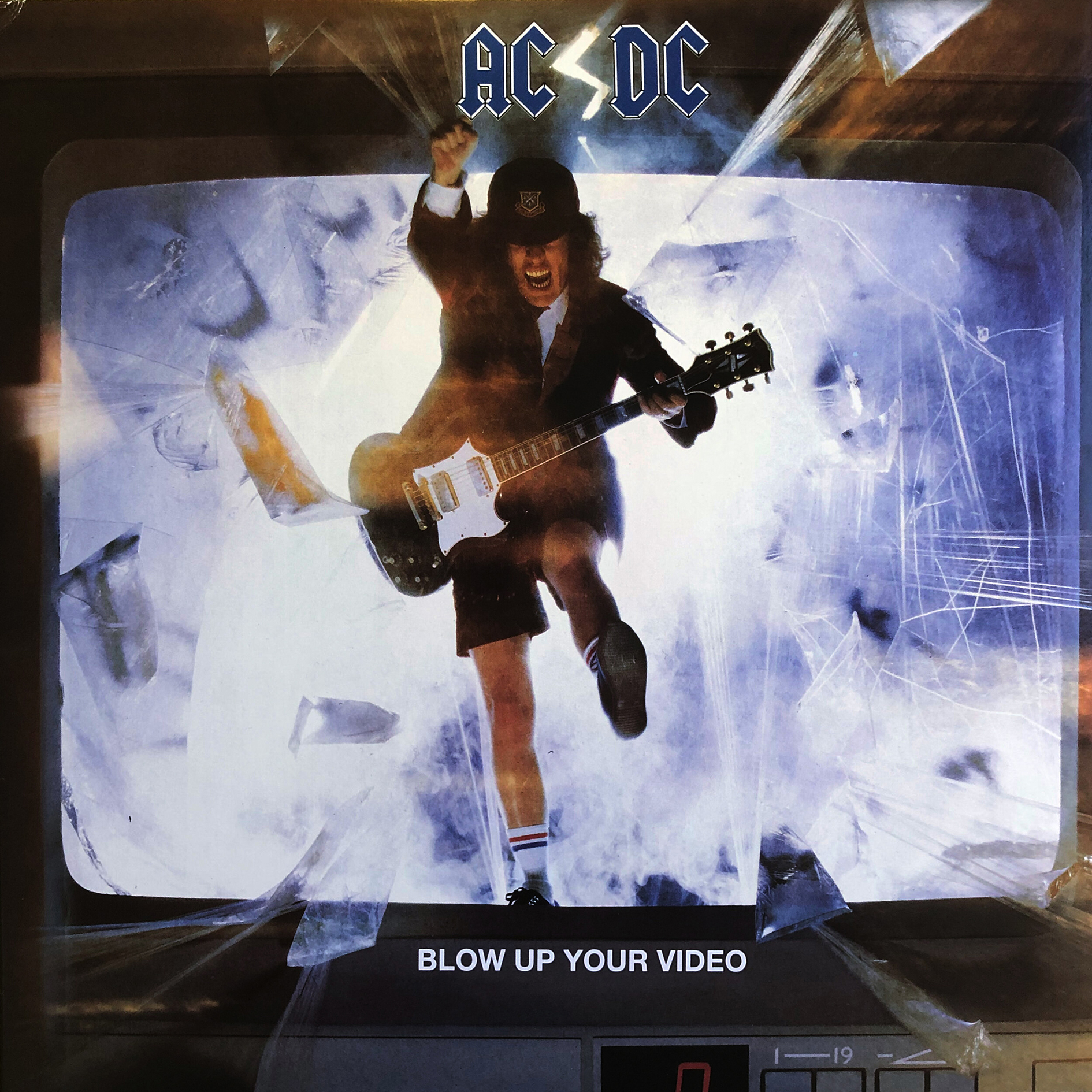 A guitarist dressed in a school uniform jumps through a television screen.