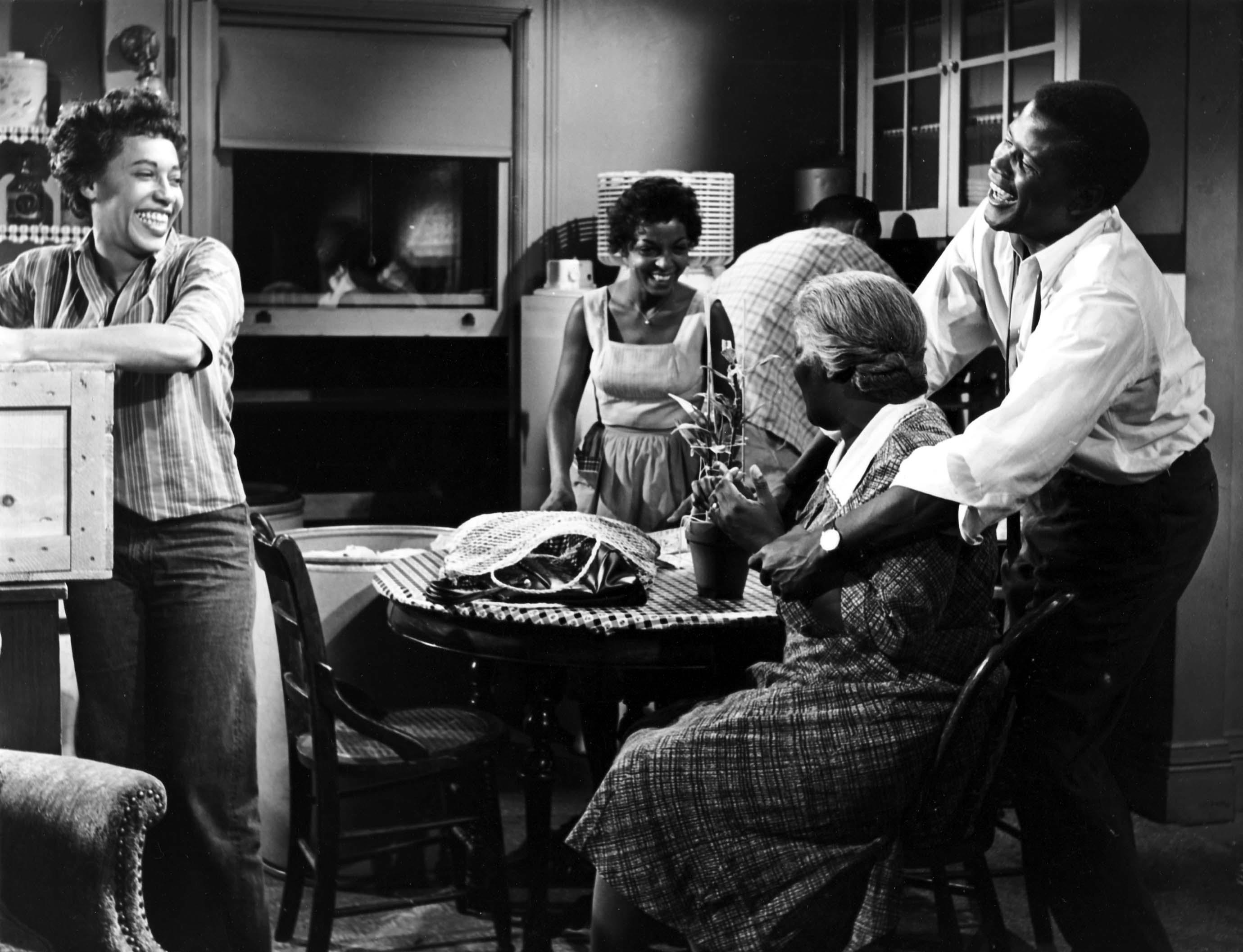 A family laughing together around a kitchen table.