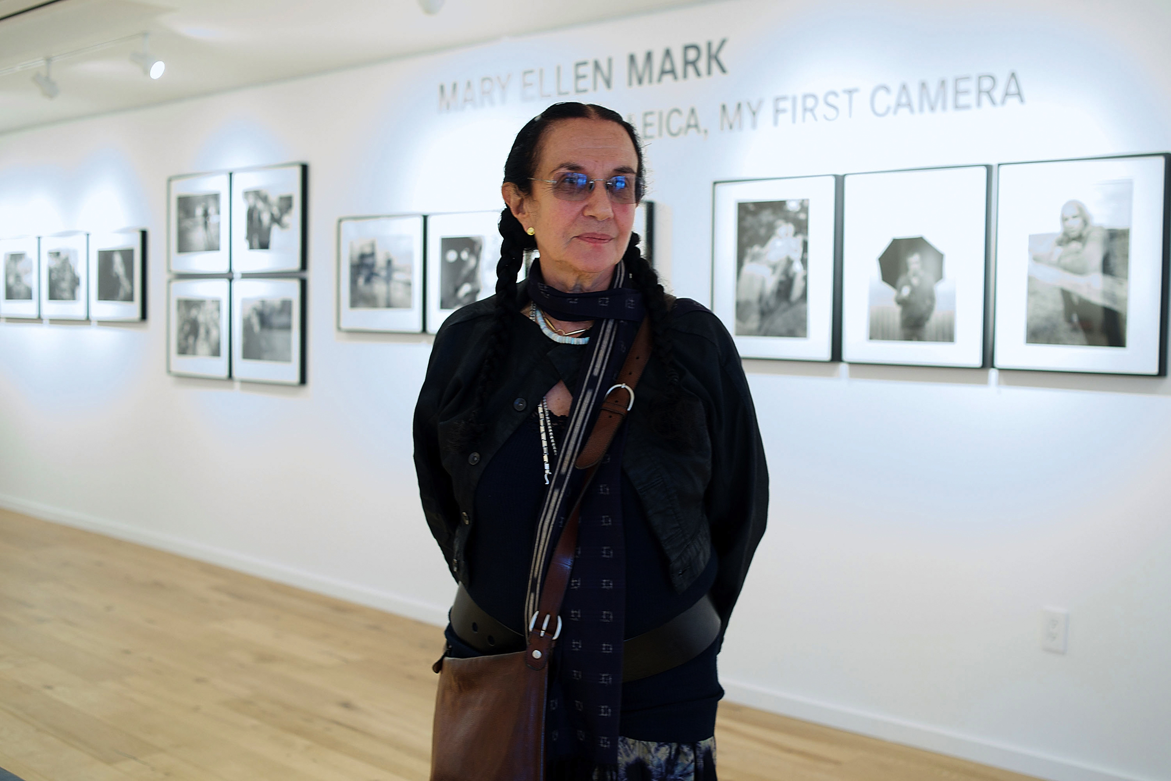 Mary Ellen Mark standing in front of her works on exhibit.