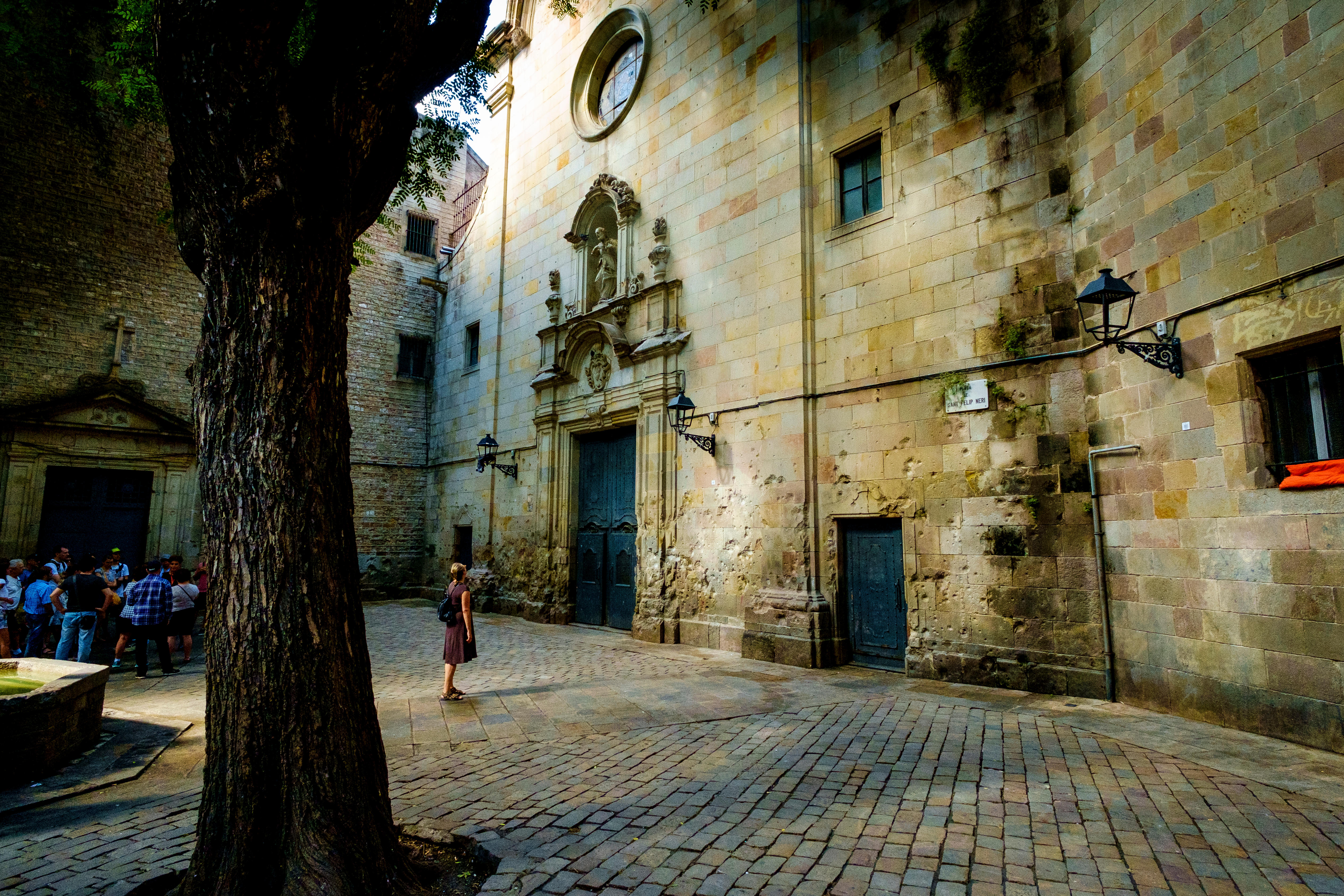 A tourist looks over Barcelona’s Sant Felip Neri church.