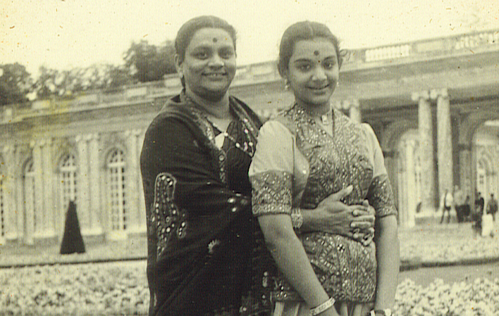 A faded photograph of a mother and daughter with the palace of Versailles in the background.