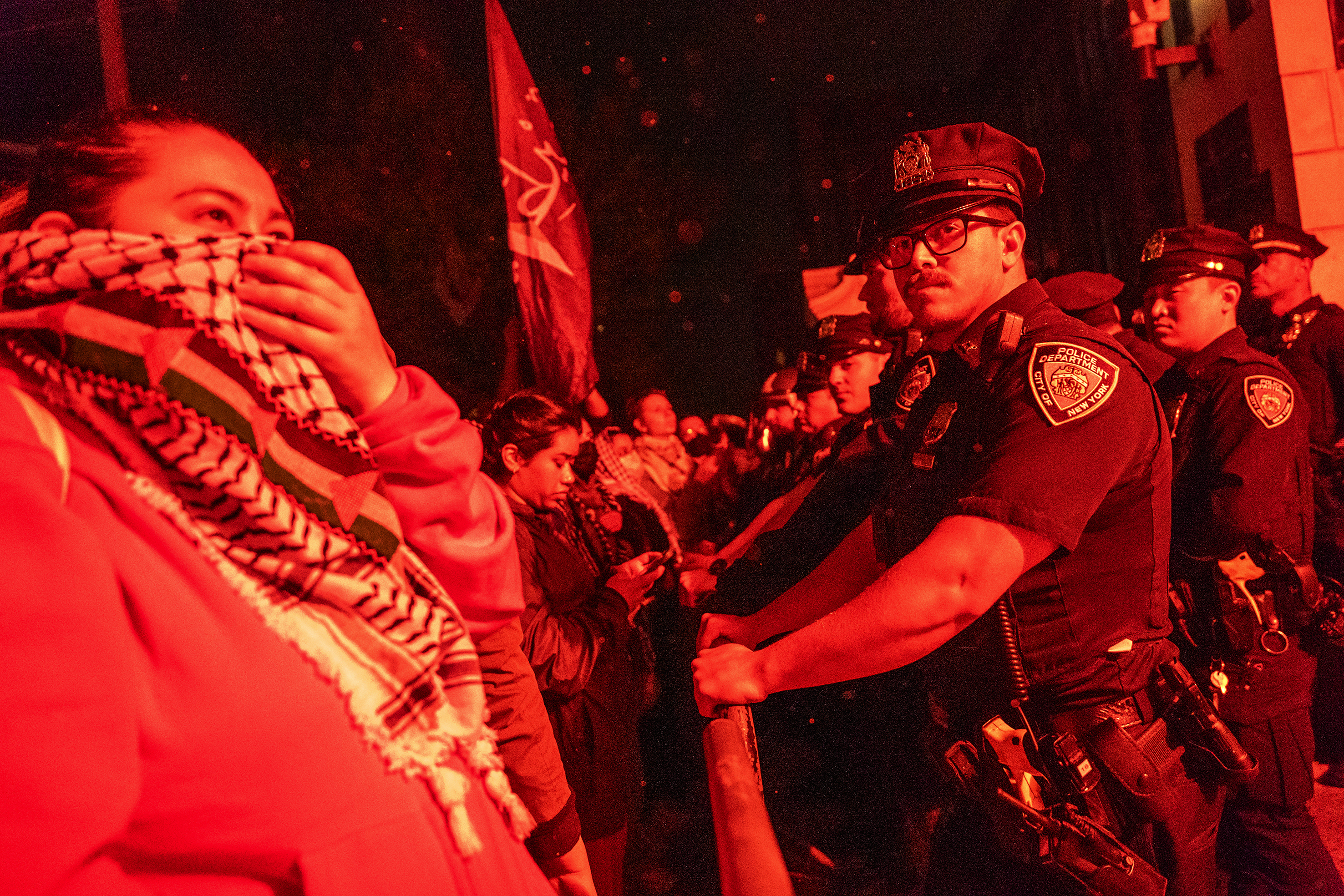 A barricade runs between protesters and police officers.