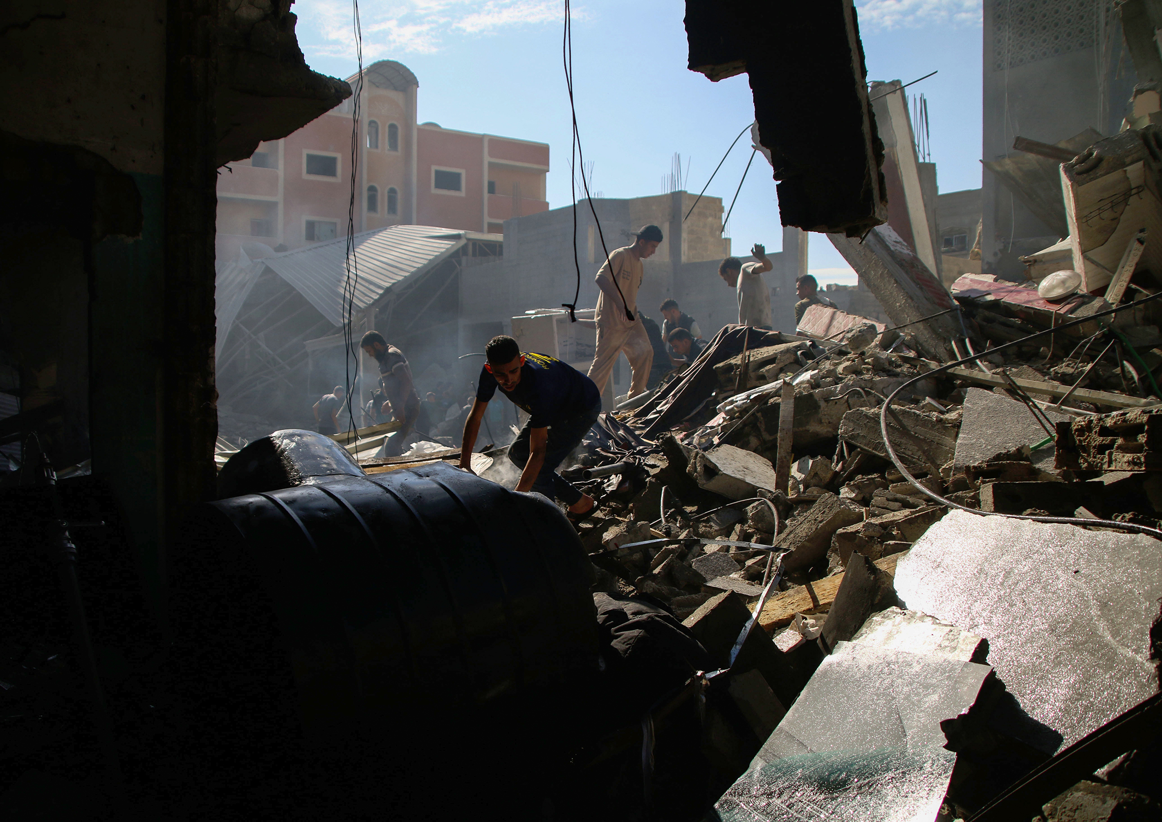 People search through the debris of a fallen building. 