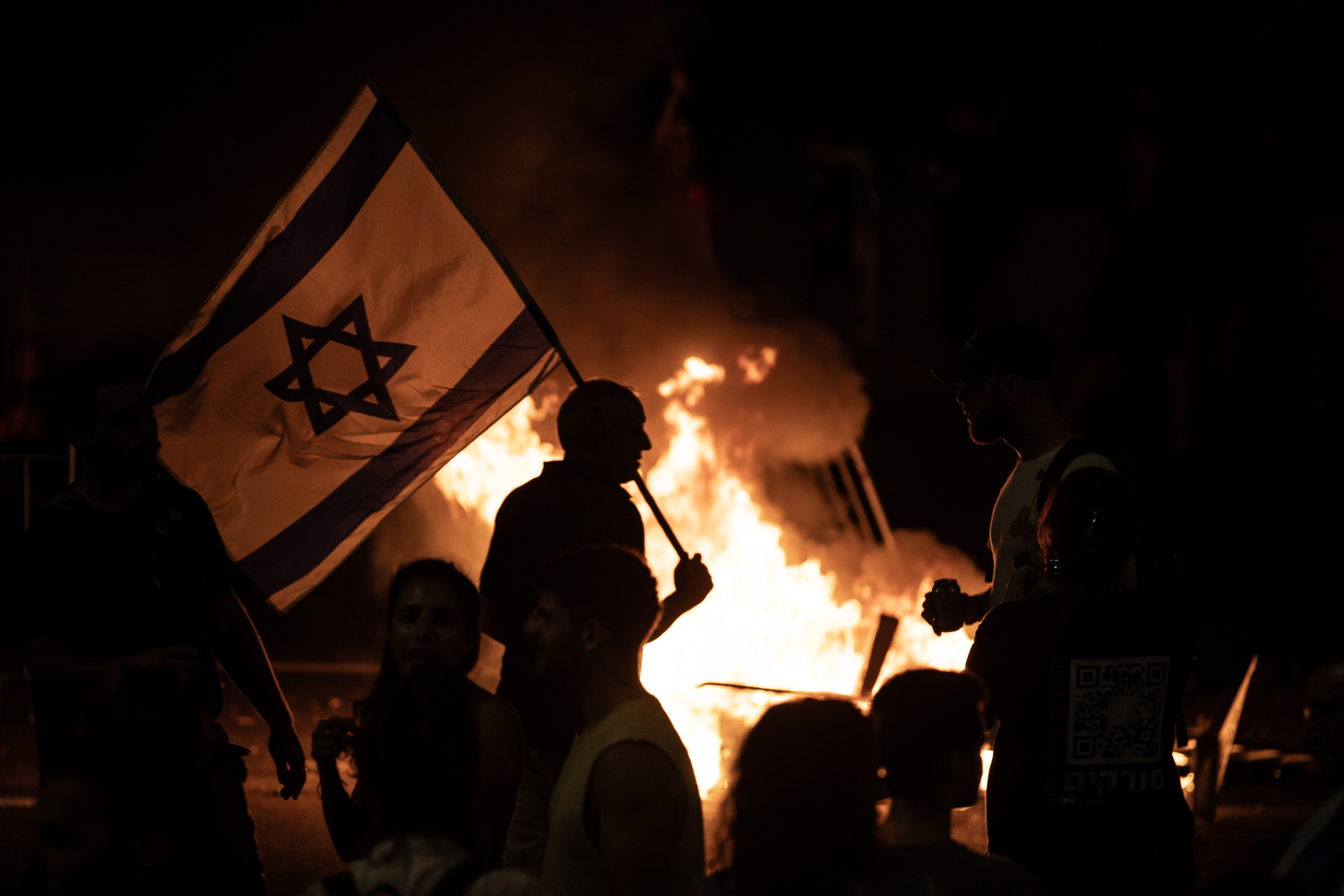 Protesters light a fire on a highway.