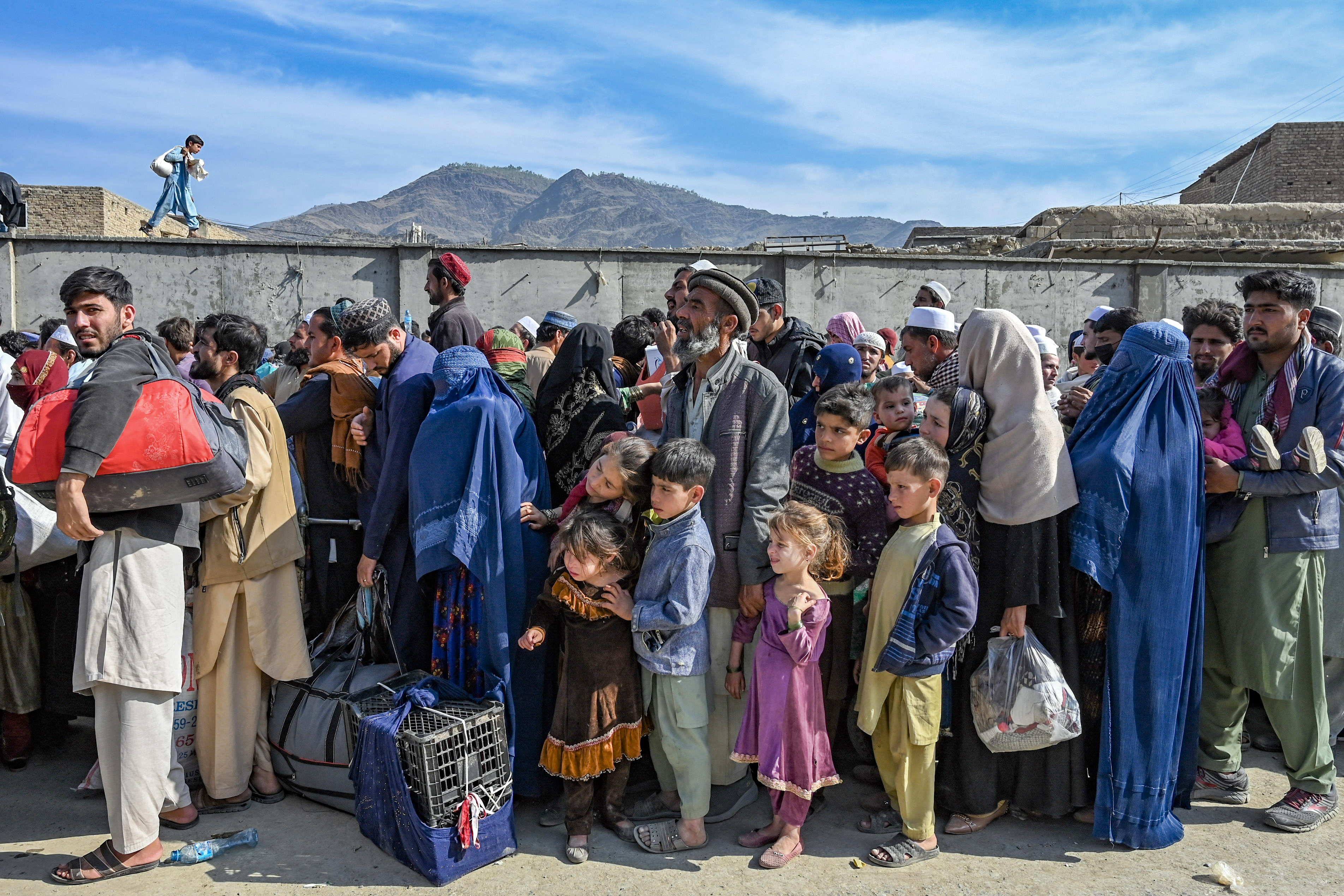 Afghan refugees wait in a queue to cross the Pakistan–Afghanistan border in Torkham.