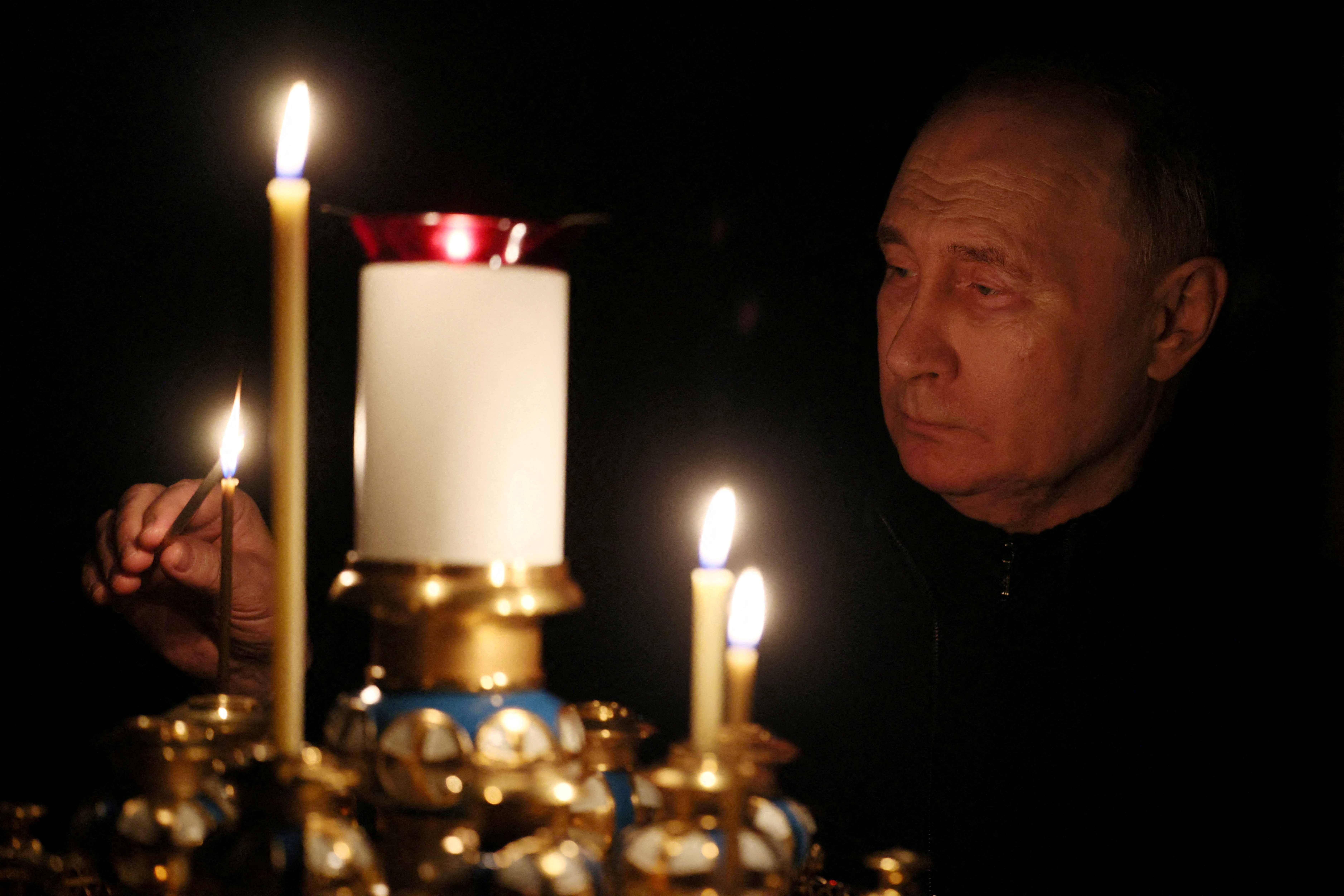 Vladimir Putin lights a candle.