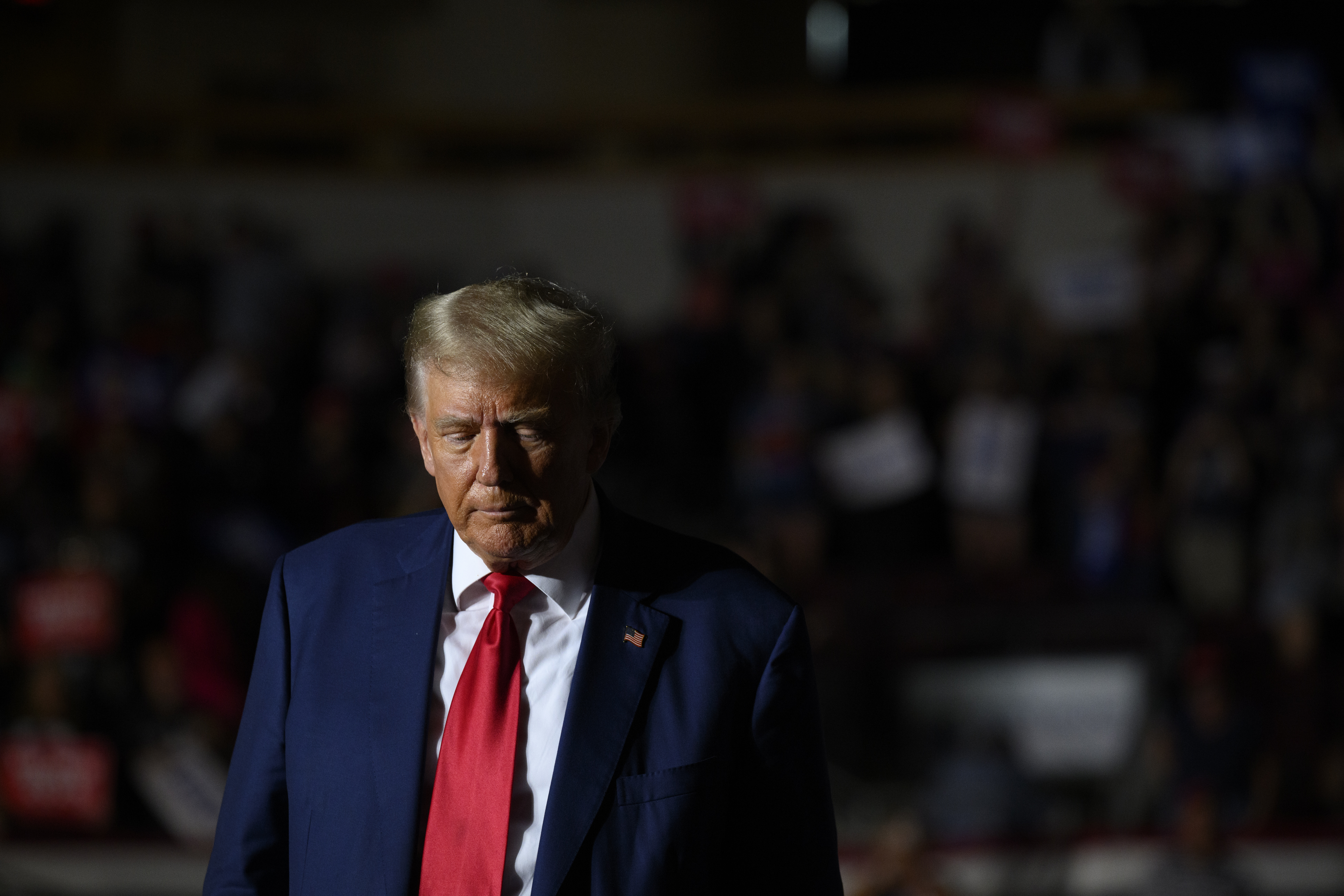 Donald trump in a navy blue suit and a red tie.