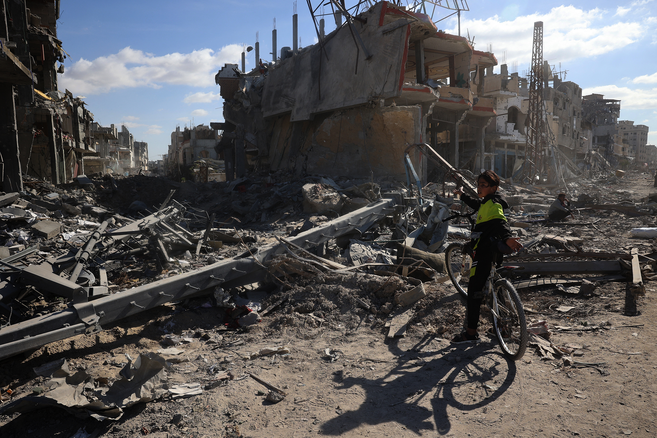 A Palestinian youth gestures to a ruined neighbourhood in Rafah, southern Gaza. 