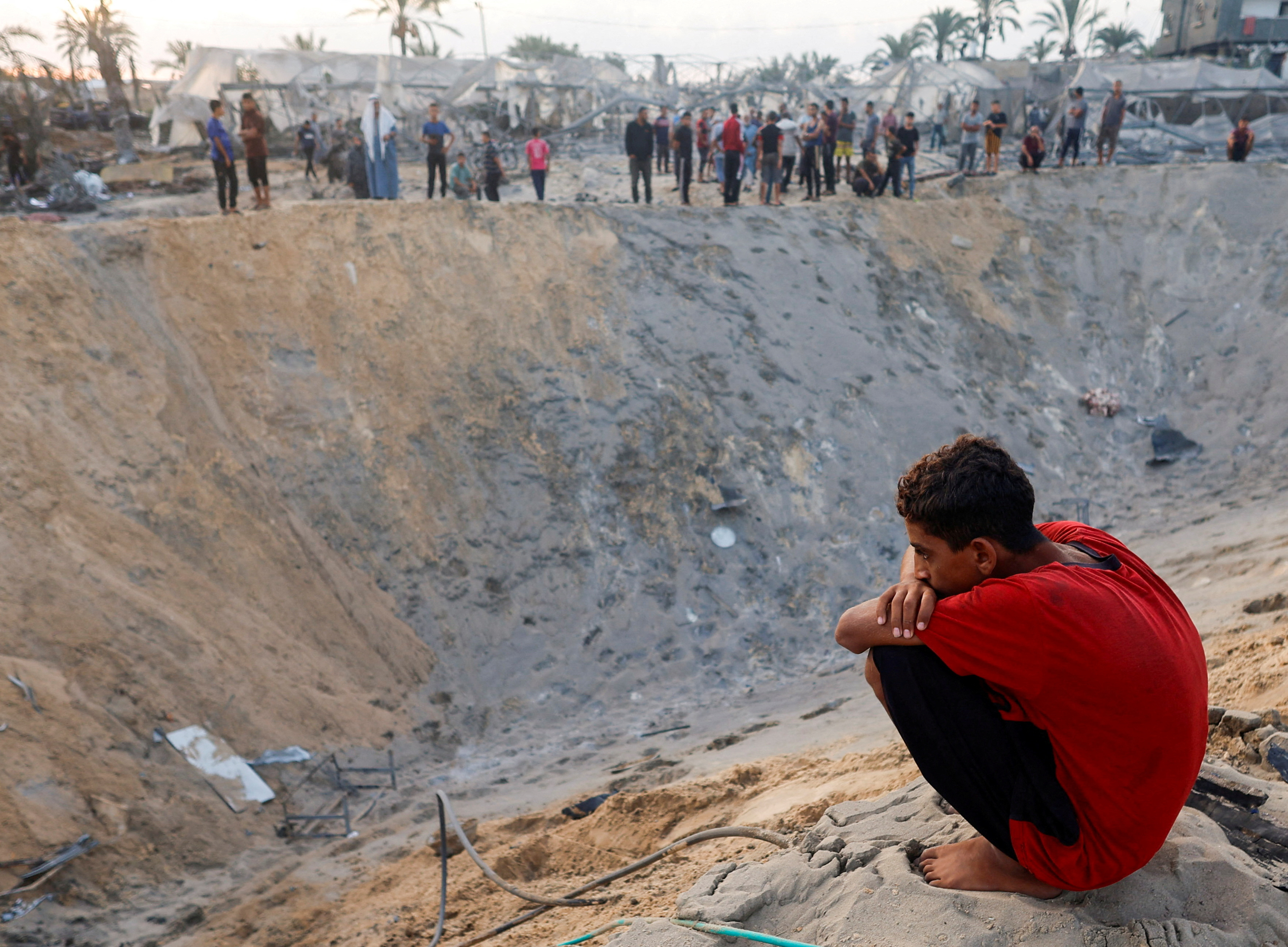 A Palestinian boy looks on after Israeli air strikes on a tent camp in the Al-Mawasi area of Khan Younis, in southern Gaza.