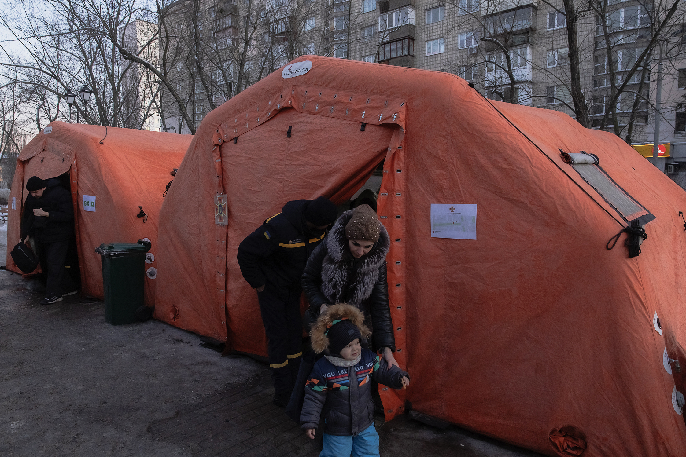 A woman and child leave an emergency service tent set up in Kyiv.