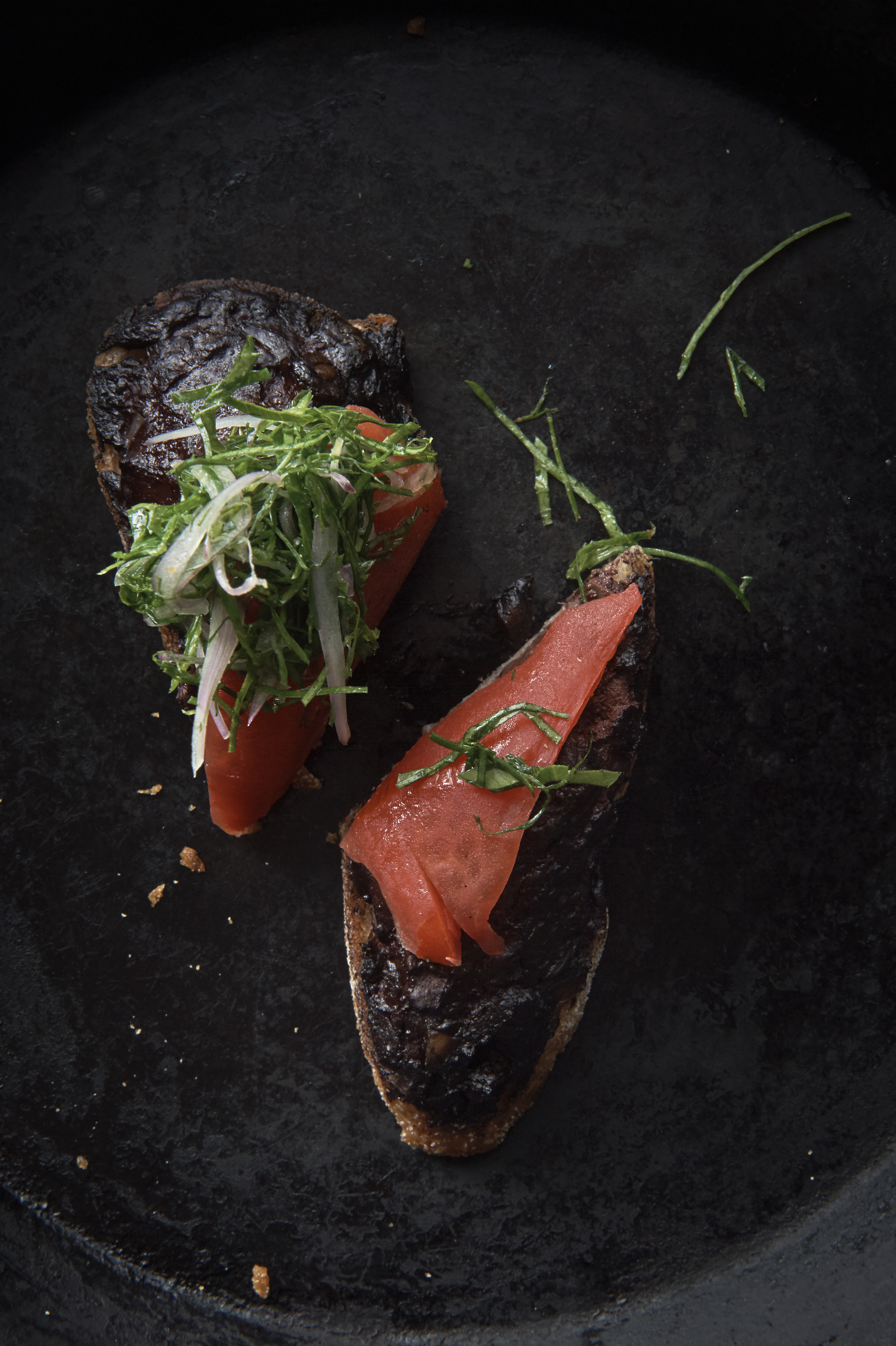 Boudin noir on toast with smoked tomato and parsley salad