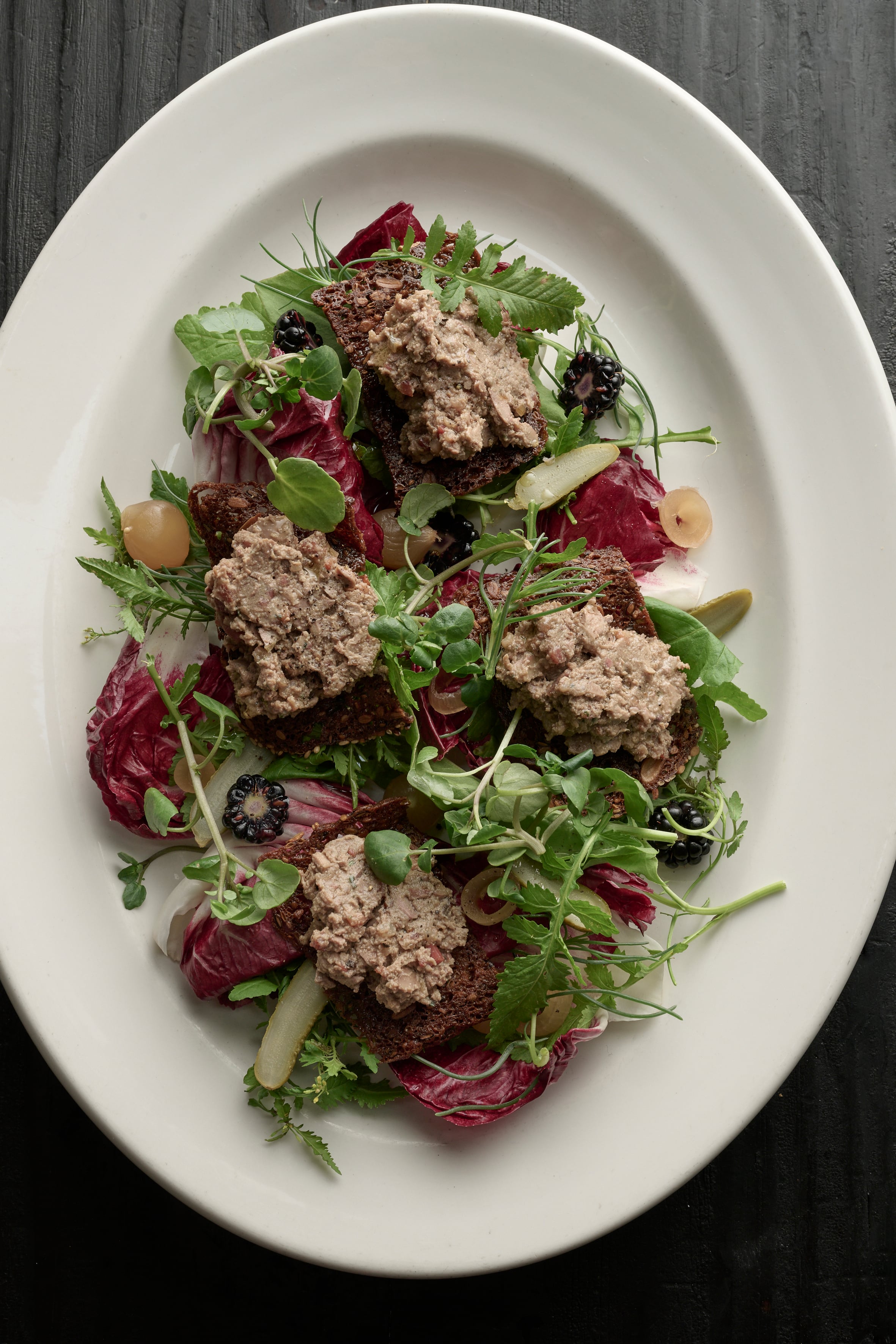 Duck liver toast with bitter leaves and blackberries