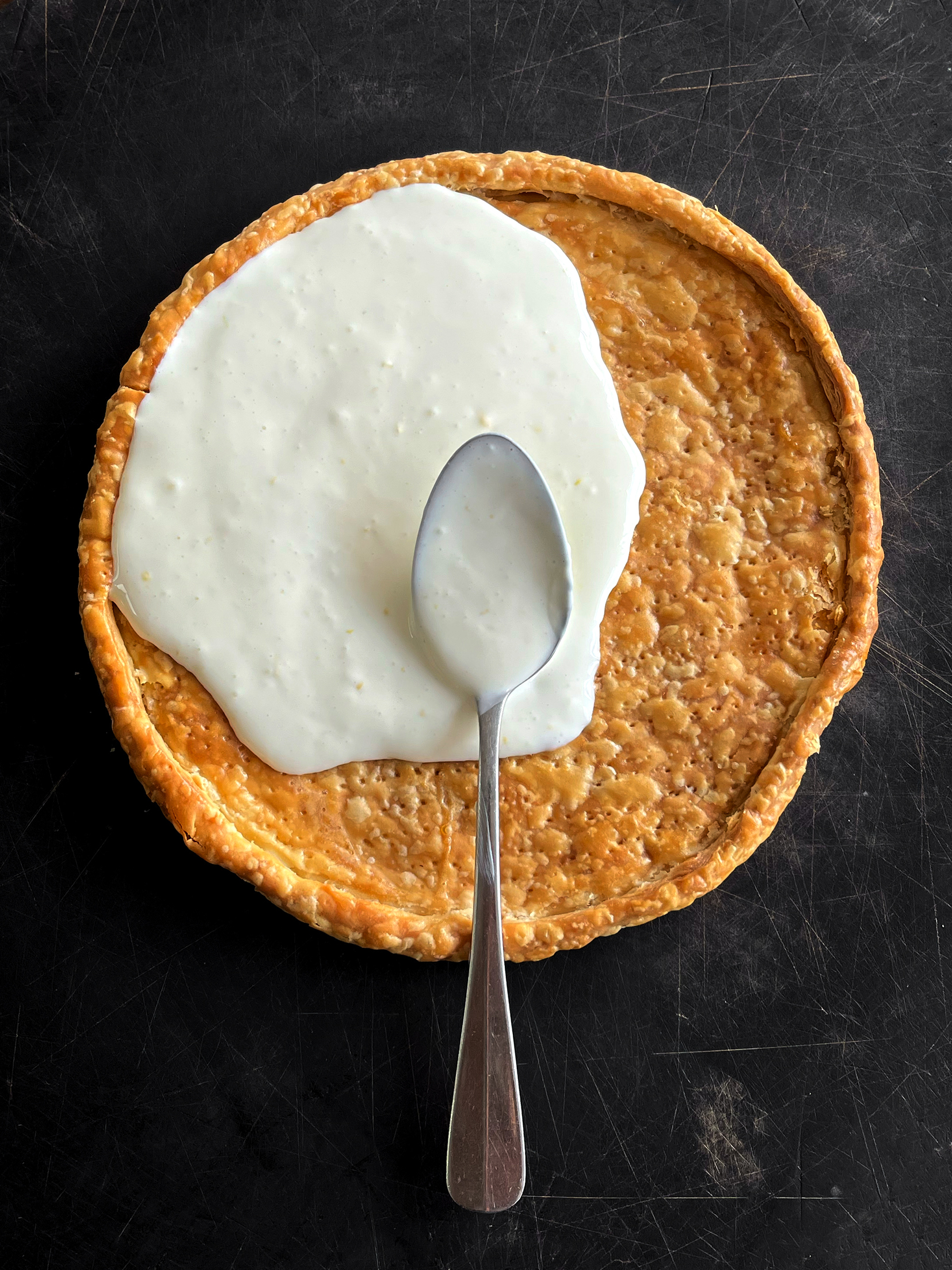 Ricotta cream pooled inside a pastry with a spoon resting in its base.